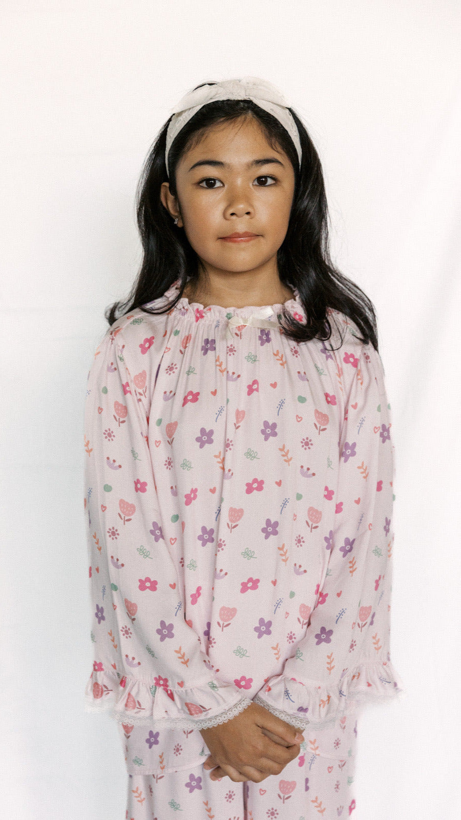Young girl wearing a floral nightgown on a white background