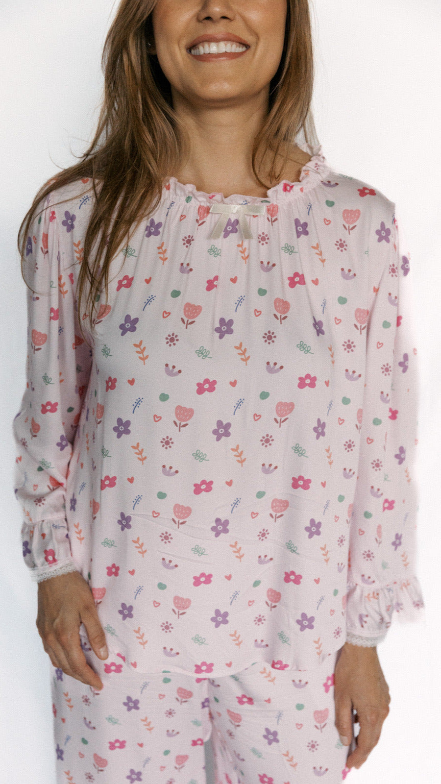 Woman wearing a floral pajama set against a white background