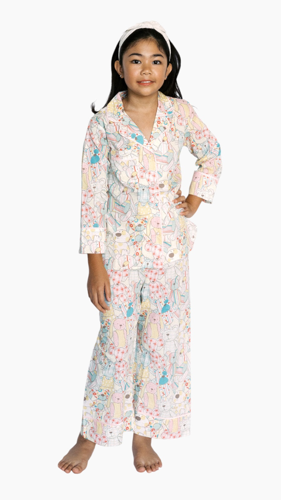 Young girl wearing cartoon bunny print PJs on a white background