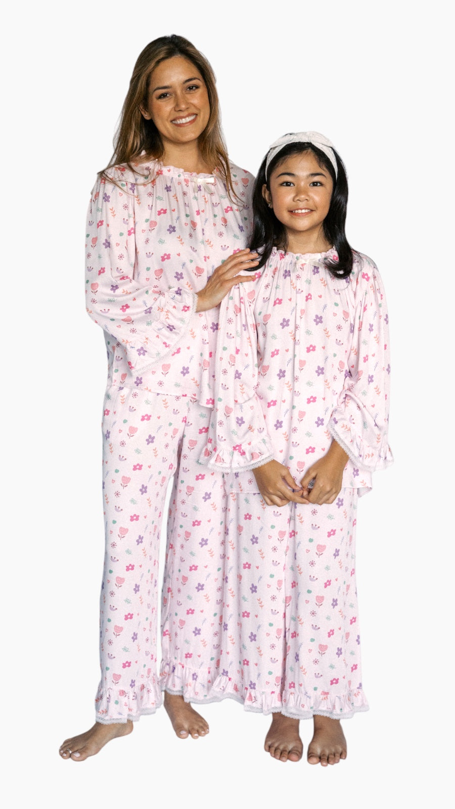 Two individuals wearing matching pink floral pajamas on a white background