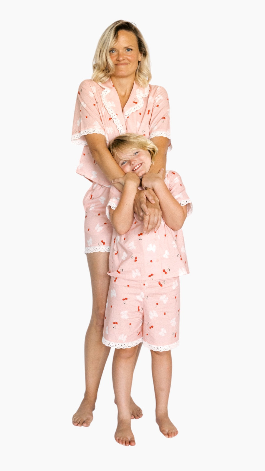 Woman and child wearing matching pink pajamas on a white background